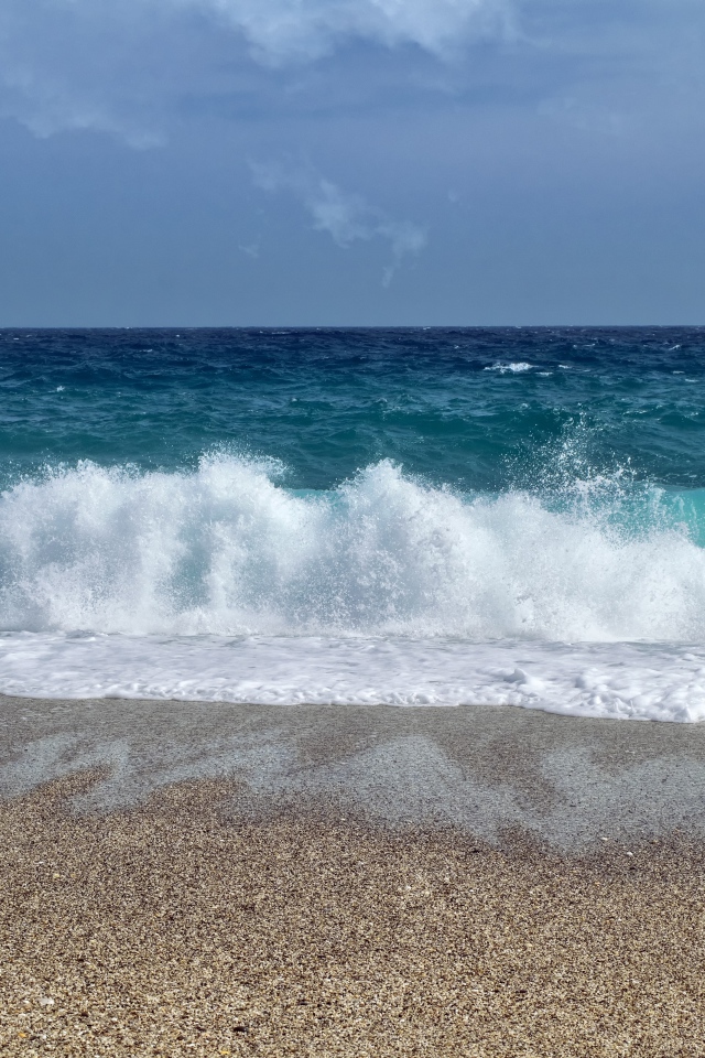 Голубые волны океана на мокром песке 
