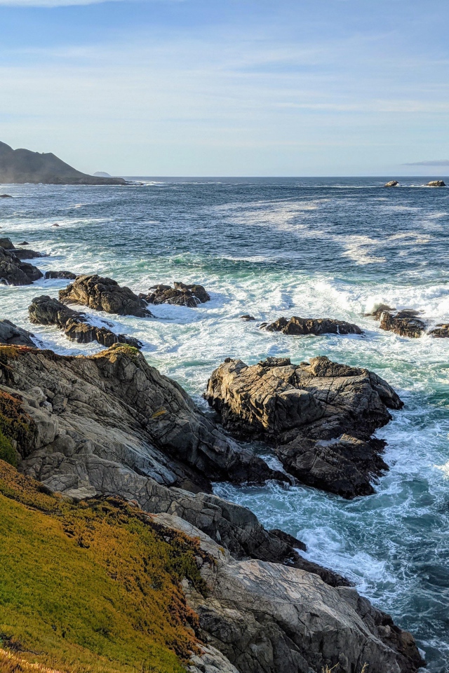 Голубая морская вода омывает камни на берегу 