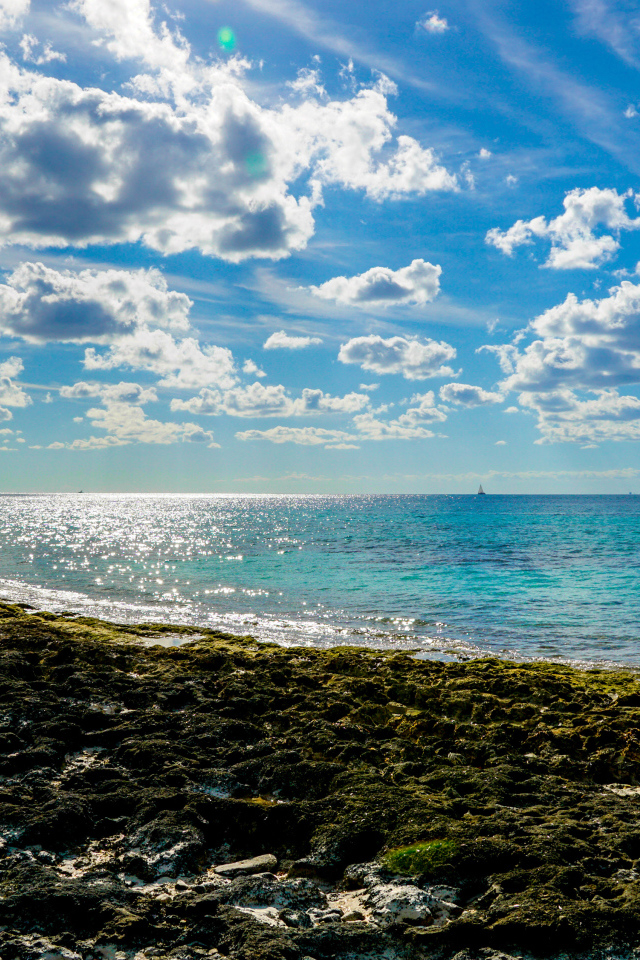 Яркое голубое небо с белыми облаками над морем