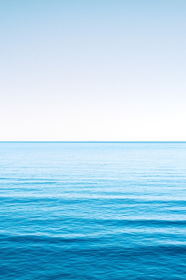 Спокойная голубая морская вода под голубым небом 