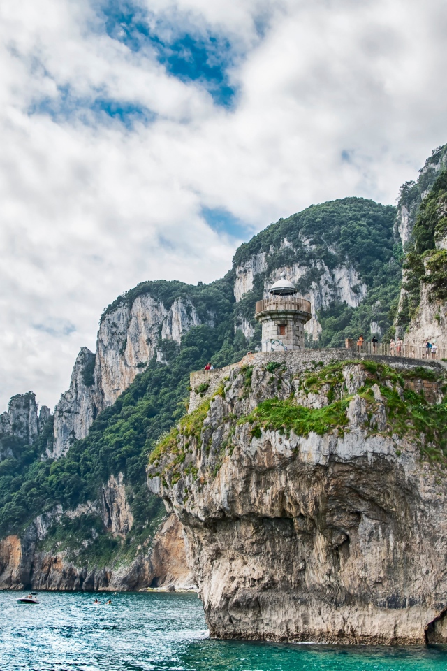 Высокие скалы у моря под белыми облаками 