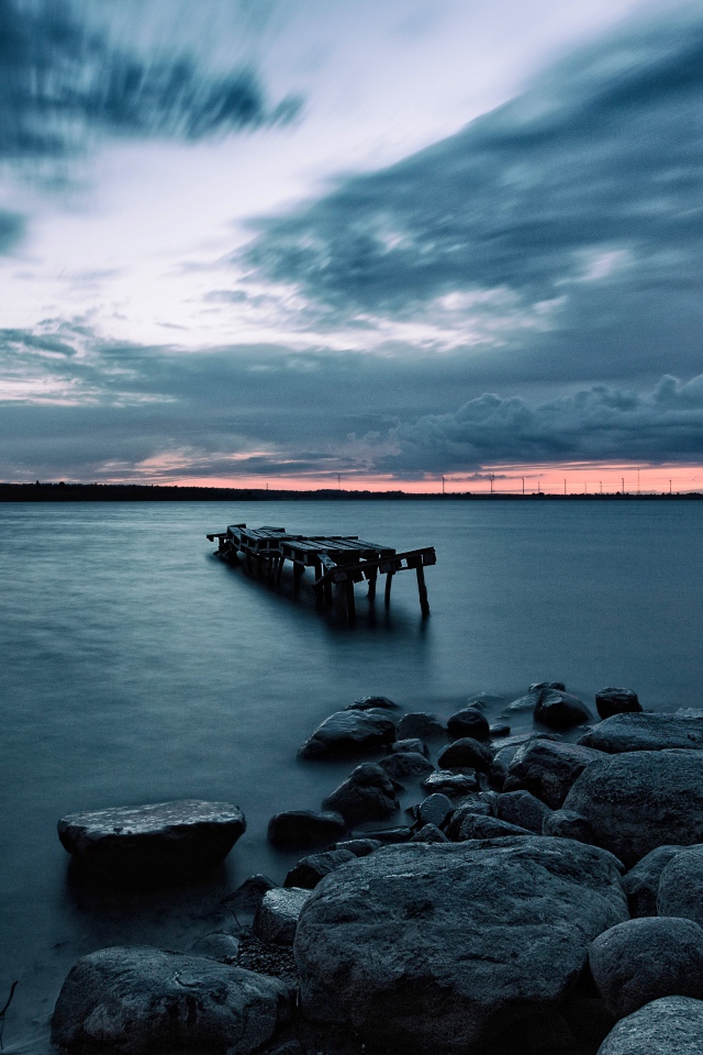 Большие камни на берегу у моря в сумерках 