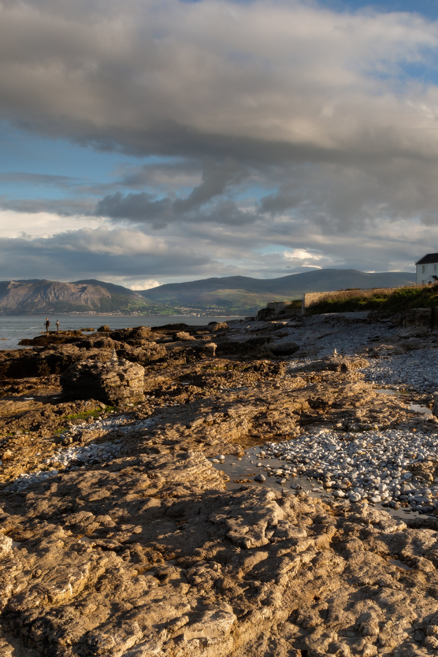 Низкие серые облака над каменным берегом у моря, Великобритания