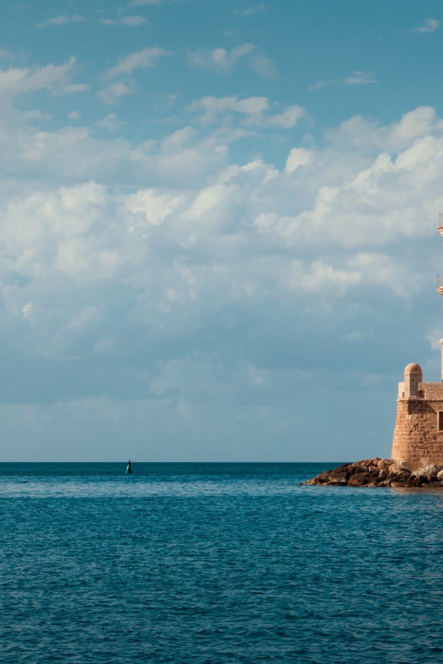 Старый красивый маяк на склоне у моря