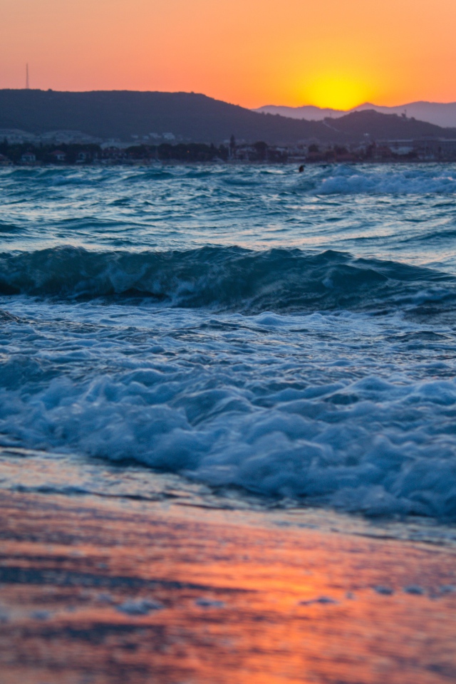 Бушующие волны на берегу моря на закате 