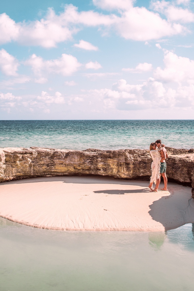 Каменное ограждение на морском пляже летом 