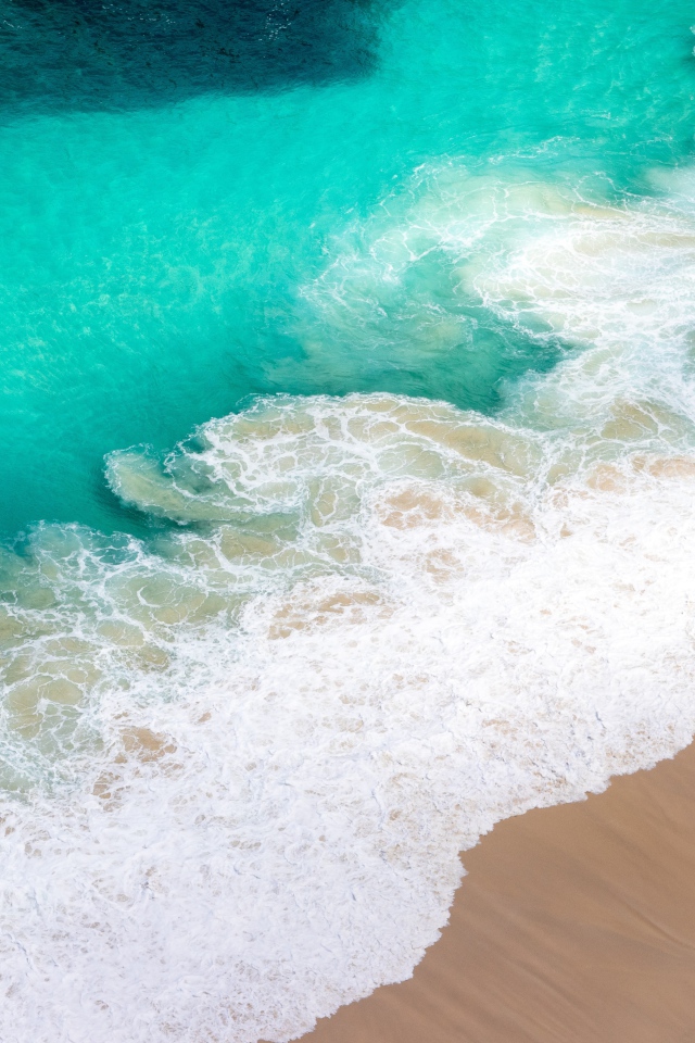 Вид сверху на белые волны прибоя 