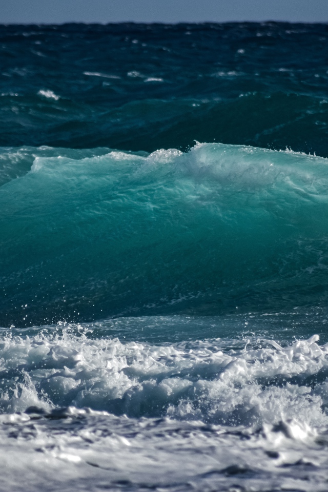 Волны с белой пеной поднимаются в море