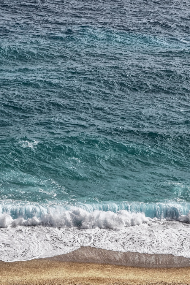 Белая пена от голубой морской воды на песке 