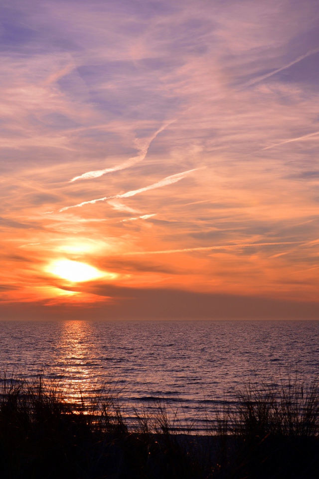 Закат солнца над спокойным озером летом