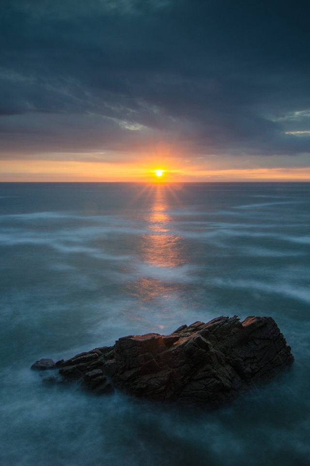 Закат солнца над покрытом льдом озером 