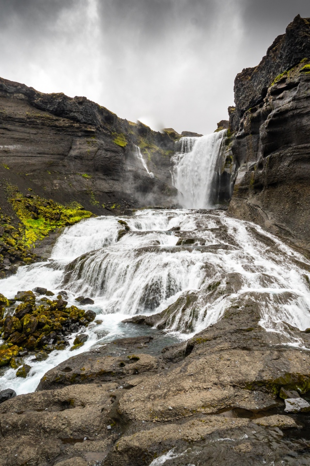 Быстрый горный водопад под серым небом