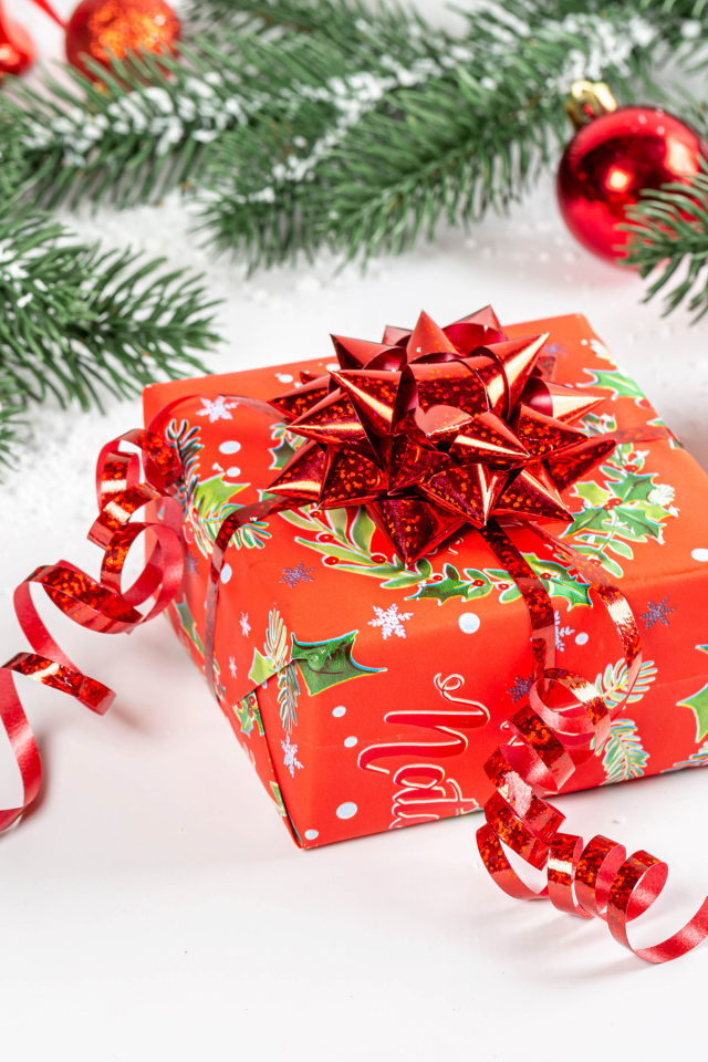 Большой красивый красный подарок с еловой веткой 