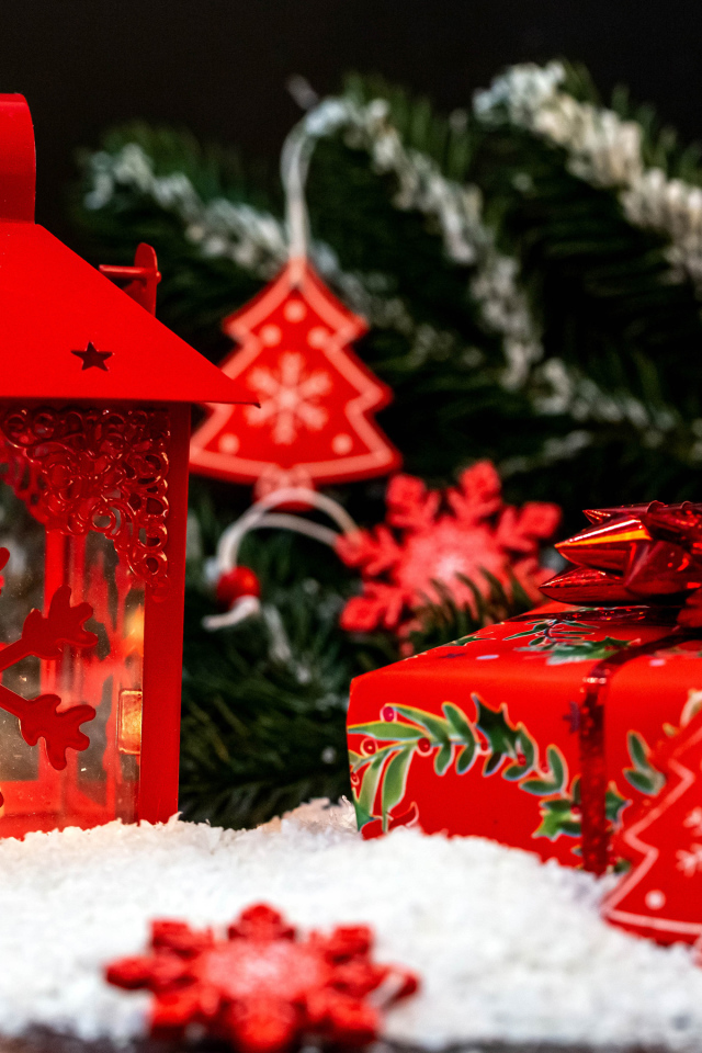 Красный фонарь с подарком у елочной ветки