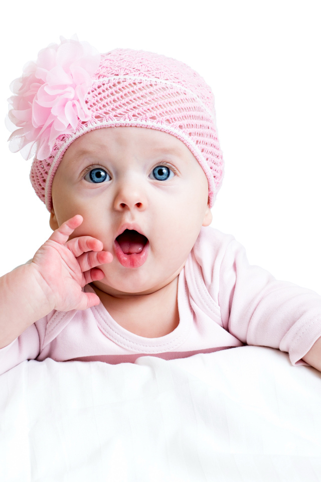 Красивая голубоглазая малышка в розовой шапке на белом фоне