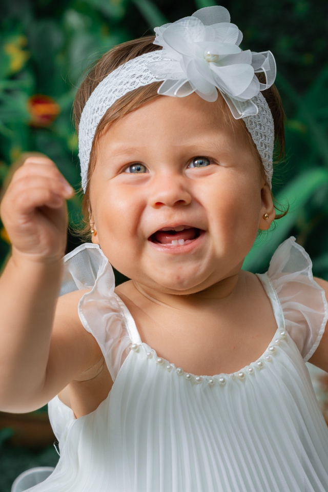 Красивая маленькая девочка в белом платье 