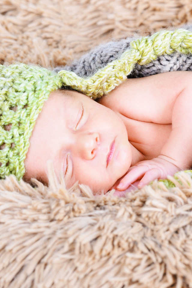 Красивый спящий грудной ребенок в вязаном костюме 