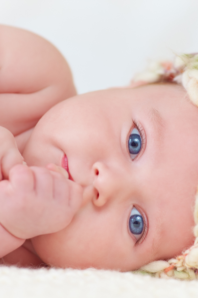 Голубоглазый грудной ребенок в шапке 