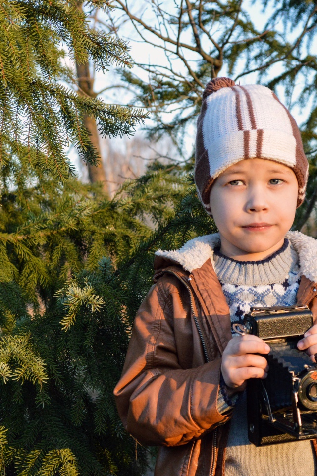 Мальчик с фотоаппаратом у ели