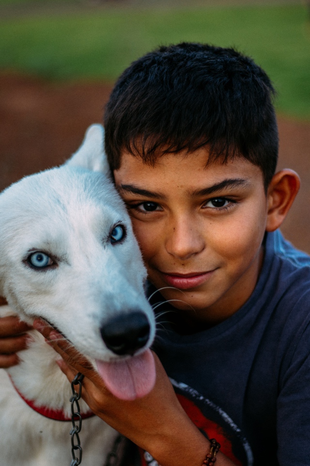 Мальчик с белой собакой с голубыми глазами 