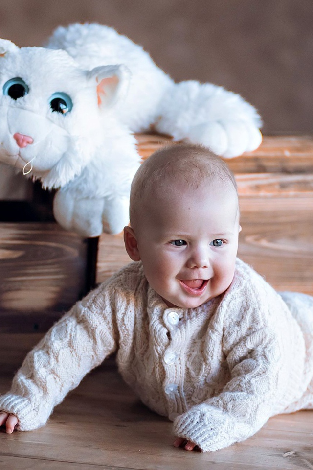 Веселый грудной ребенок с игрушечной машинкой 