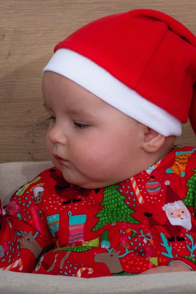 Ребенок в новогодней шапке с игрушкой в руке