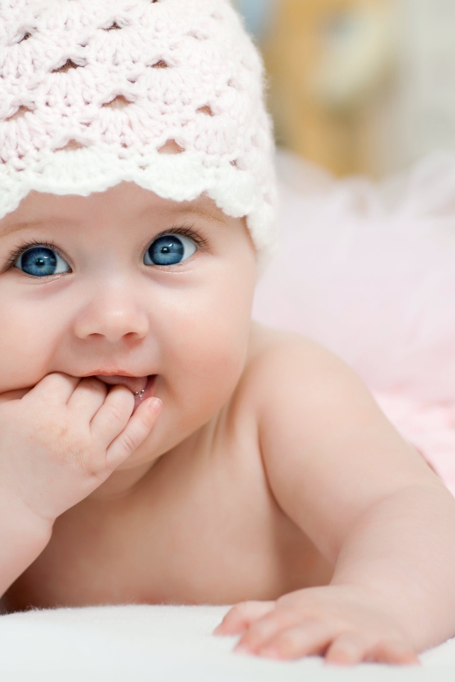 Милая голубоглазая малышка в розовой шапке 