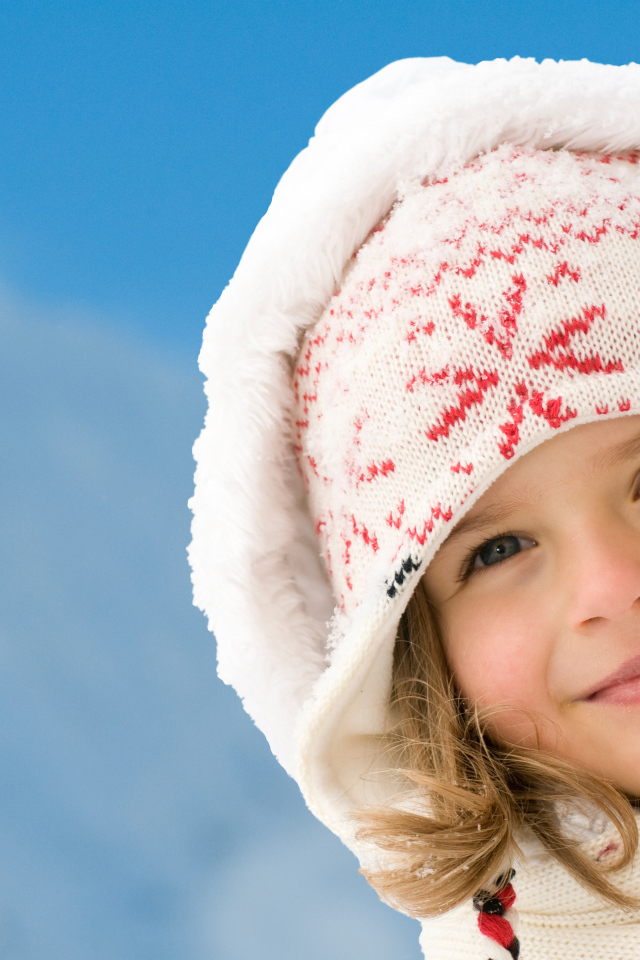 Милая маленькая девочка в шапке на фоне неба