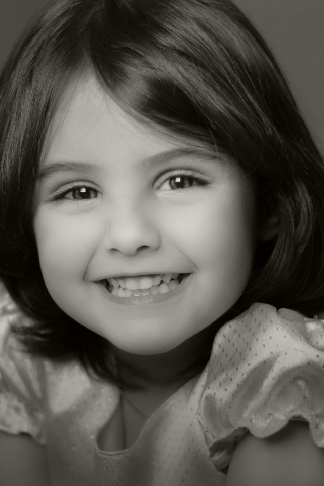 Милая улыбающаяся маленькая девочка черно-белое фото