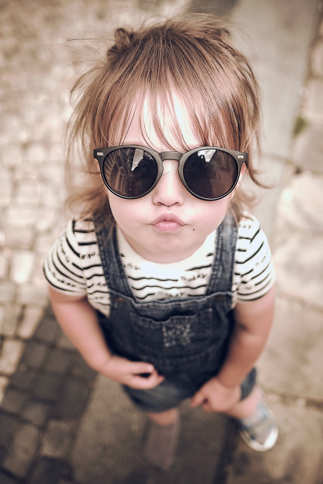 Модная маленькая девочка в черных очках