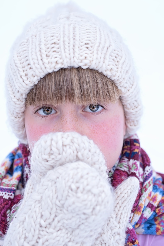 Девочка в рукавицах и белой шапке