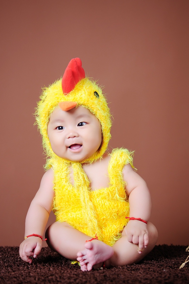 Маленький мальчик азиат в костюме цыпленка