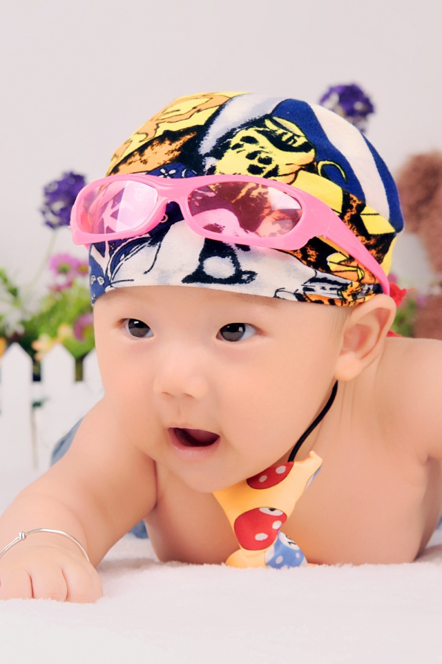 Маленький ребенок азиат в шапке с очками