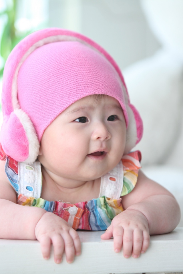 Маленький ребенок азиат в розовой шапке 