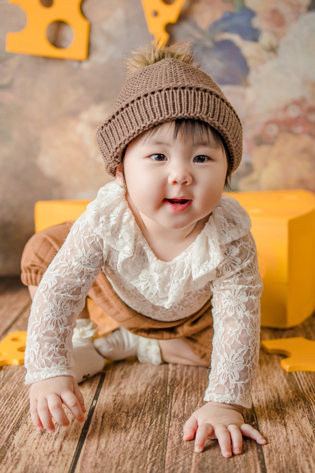 Маленький азиатский ребенок на полу с игрушками