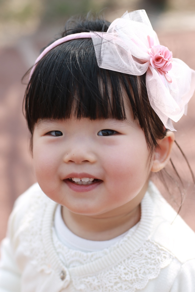 Маленькая девочка азиатка с бантом на голове 