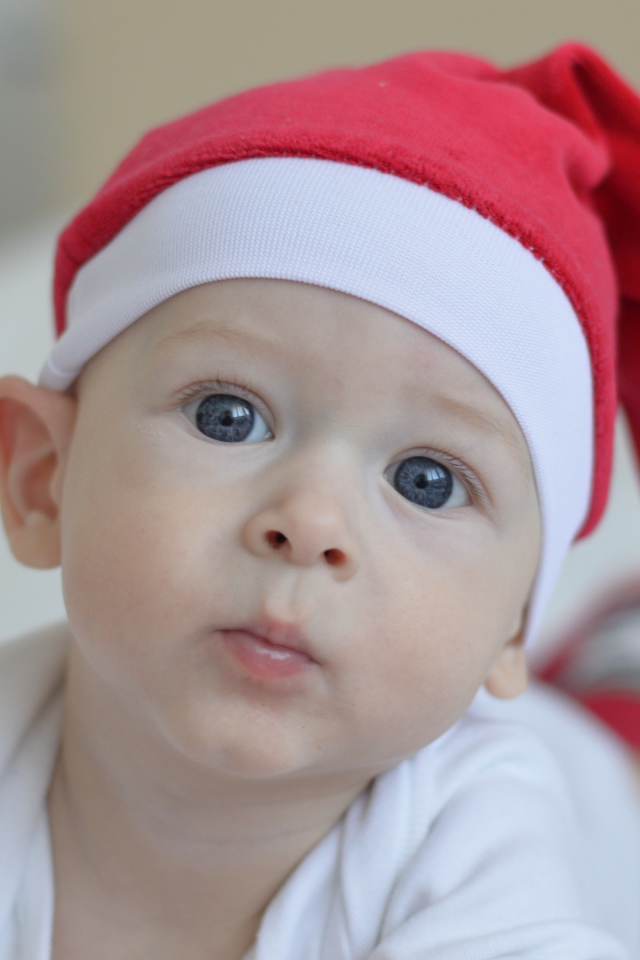 Маленький голубоглазый мальчик в красной шапке Санты