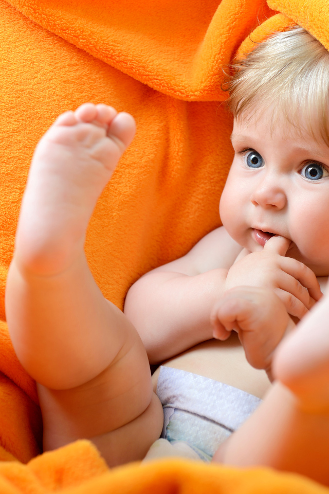 Маленький голубоглазый ребенок в желтом покрывале 