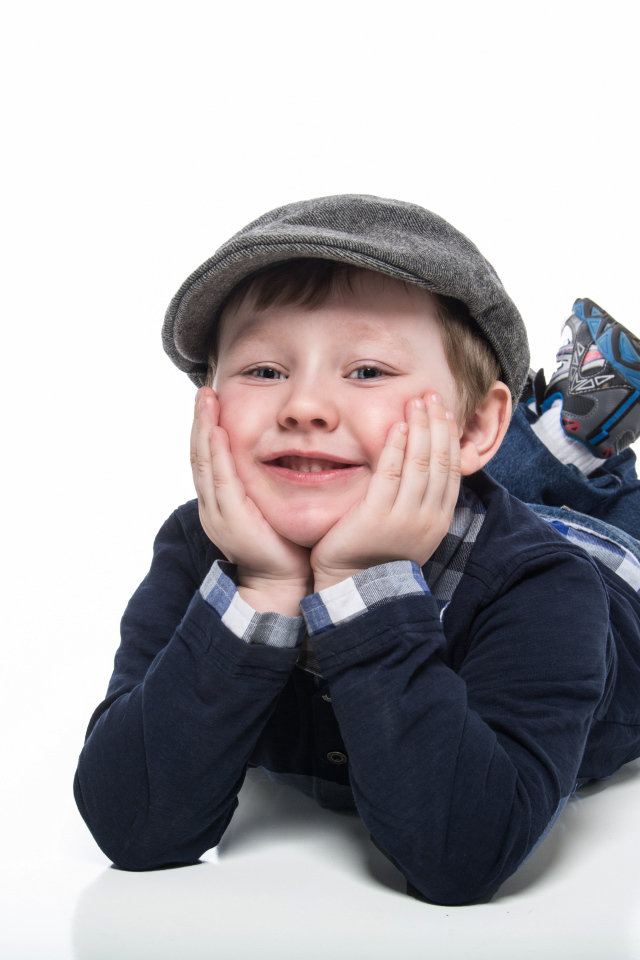 Маленький мальчик в кепке на белом фоне