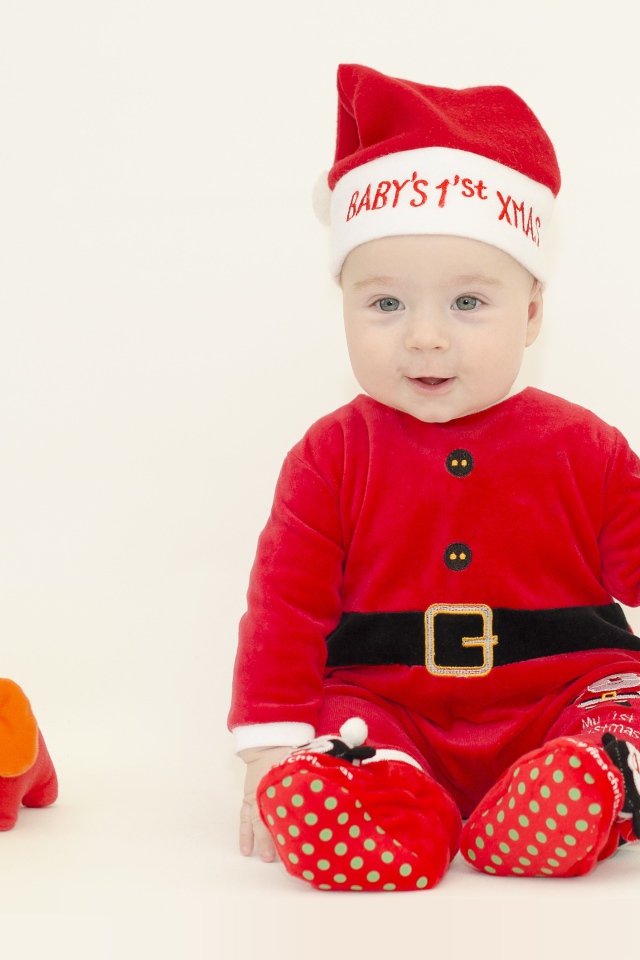 Маленький мальчик в новогоднем костюме на белом фоне