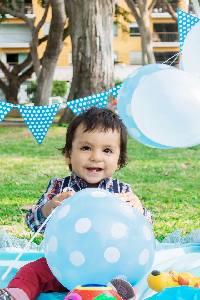 Маленький мальчик с шарами и украшениями на день рождения 