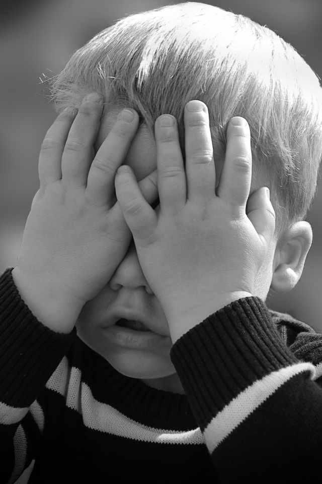 Маленький ребенок закрыл глаза руками