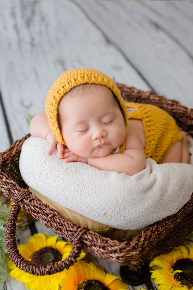 Маленький ребенок спит в плетеной корзине 