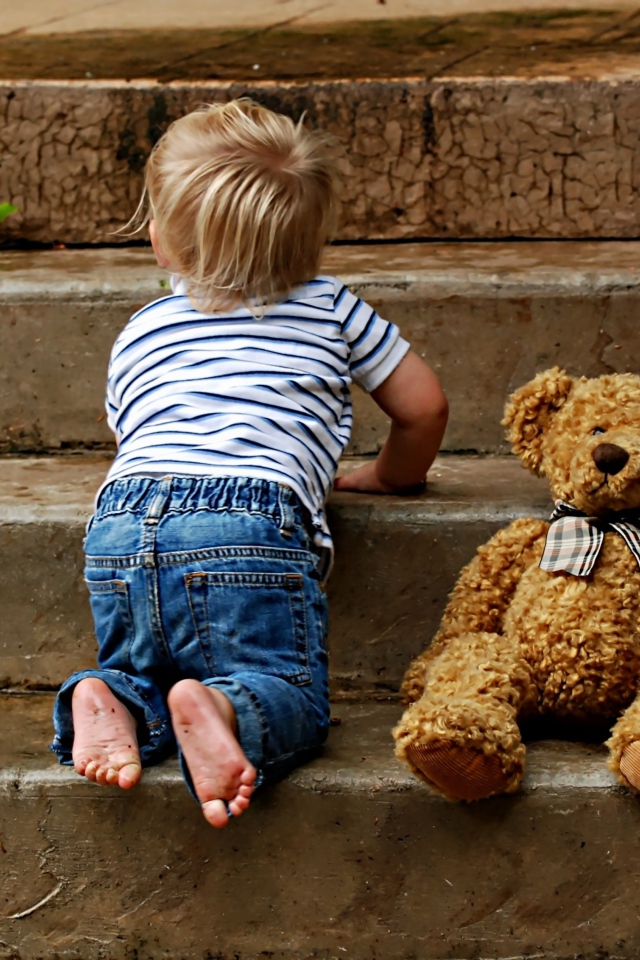 Маленький ребенок с медведем на ступеньках