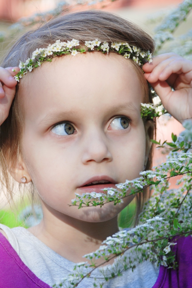 Маленькая девочка украсила голову белым цветком 