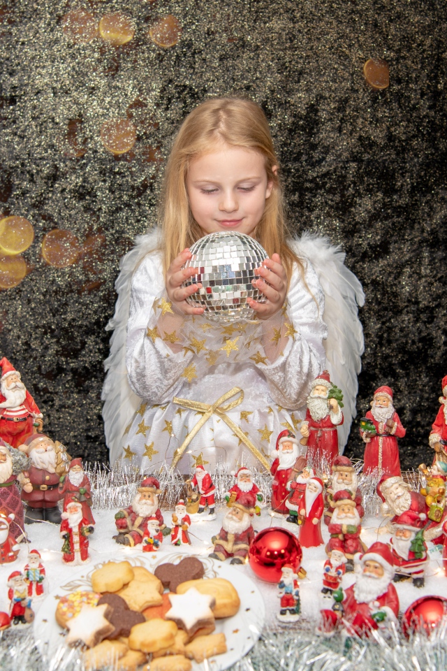 Маленькая девочка в костюме ангела с новогодним декором