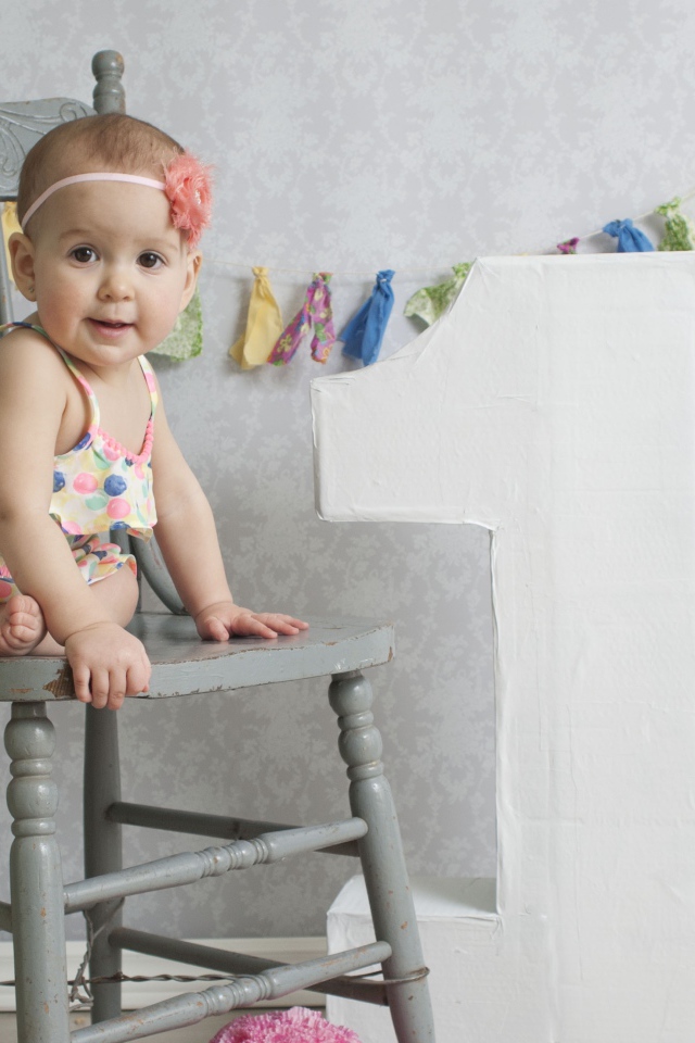 Маленькая девочка в платье на стуле