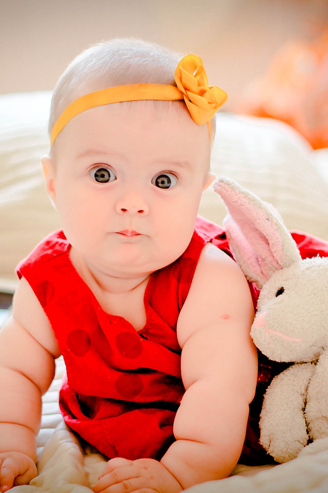 Маленькая девочка в красном платье с игрушкой 