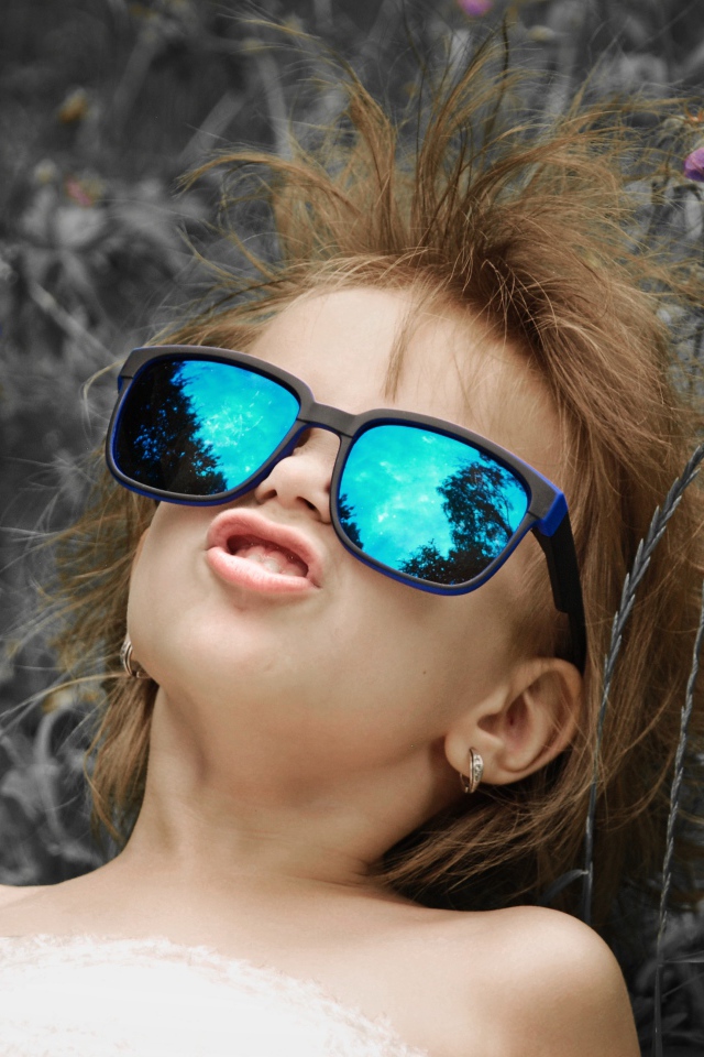 Маленькая девочка в очках со смешной прической