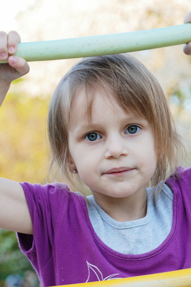 Маленькая девочка на подвесной лестнице 